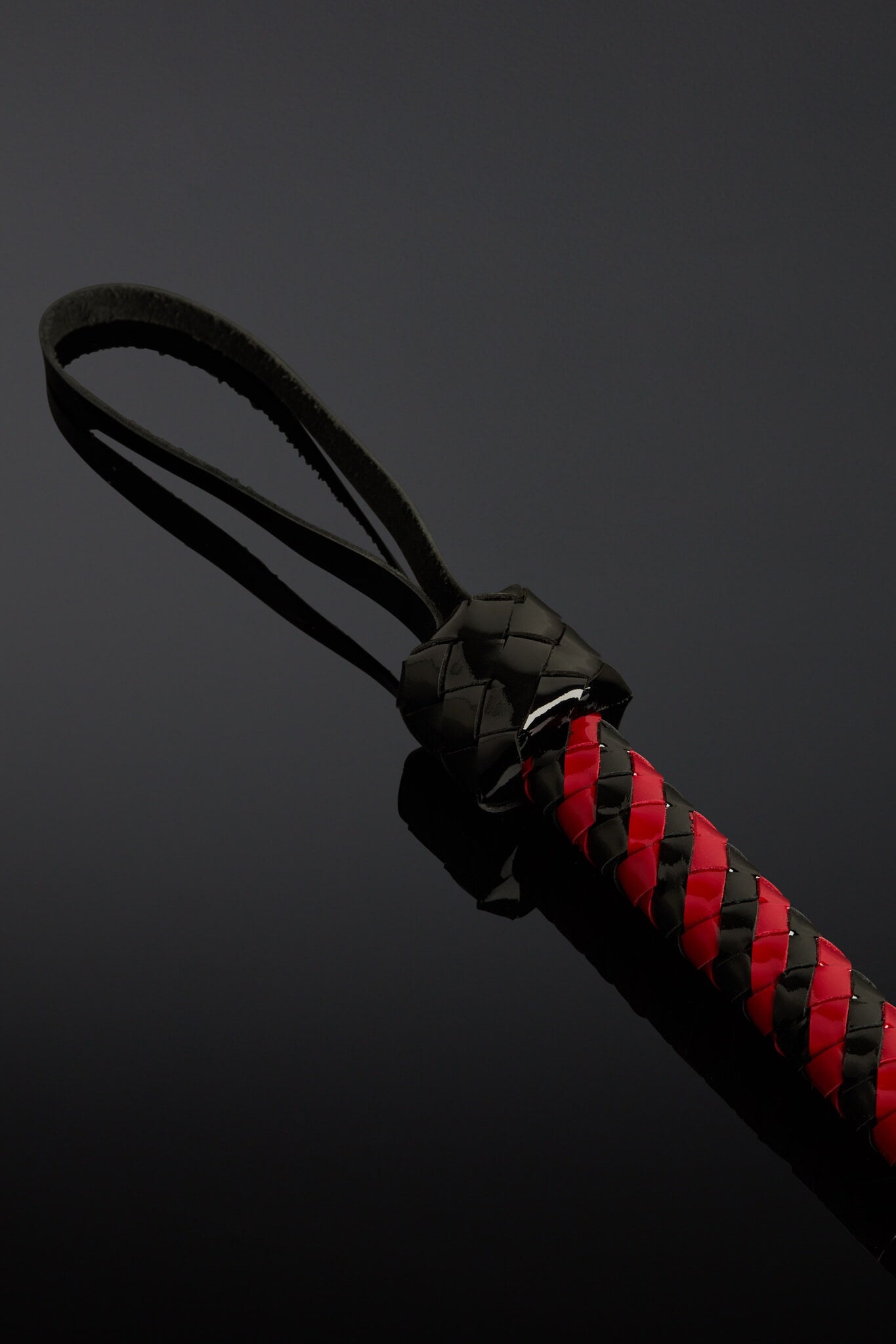 Black and red braided lanyard on a dark background