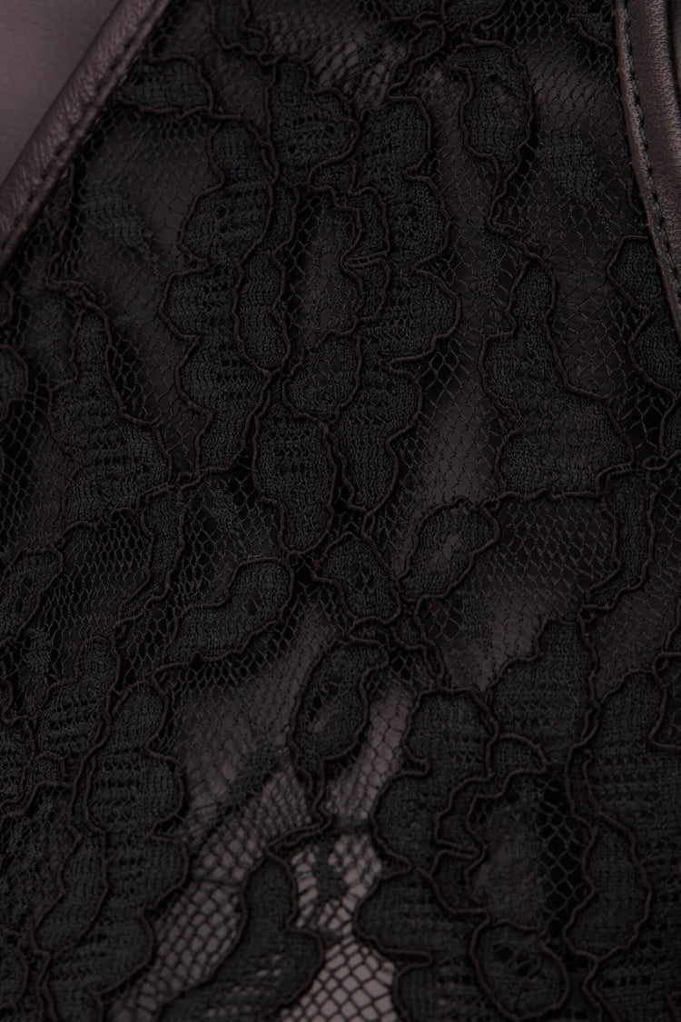 Close-up of black lace fabric with a sheer mesh overlay and scalloped floral pattern.