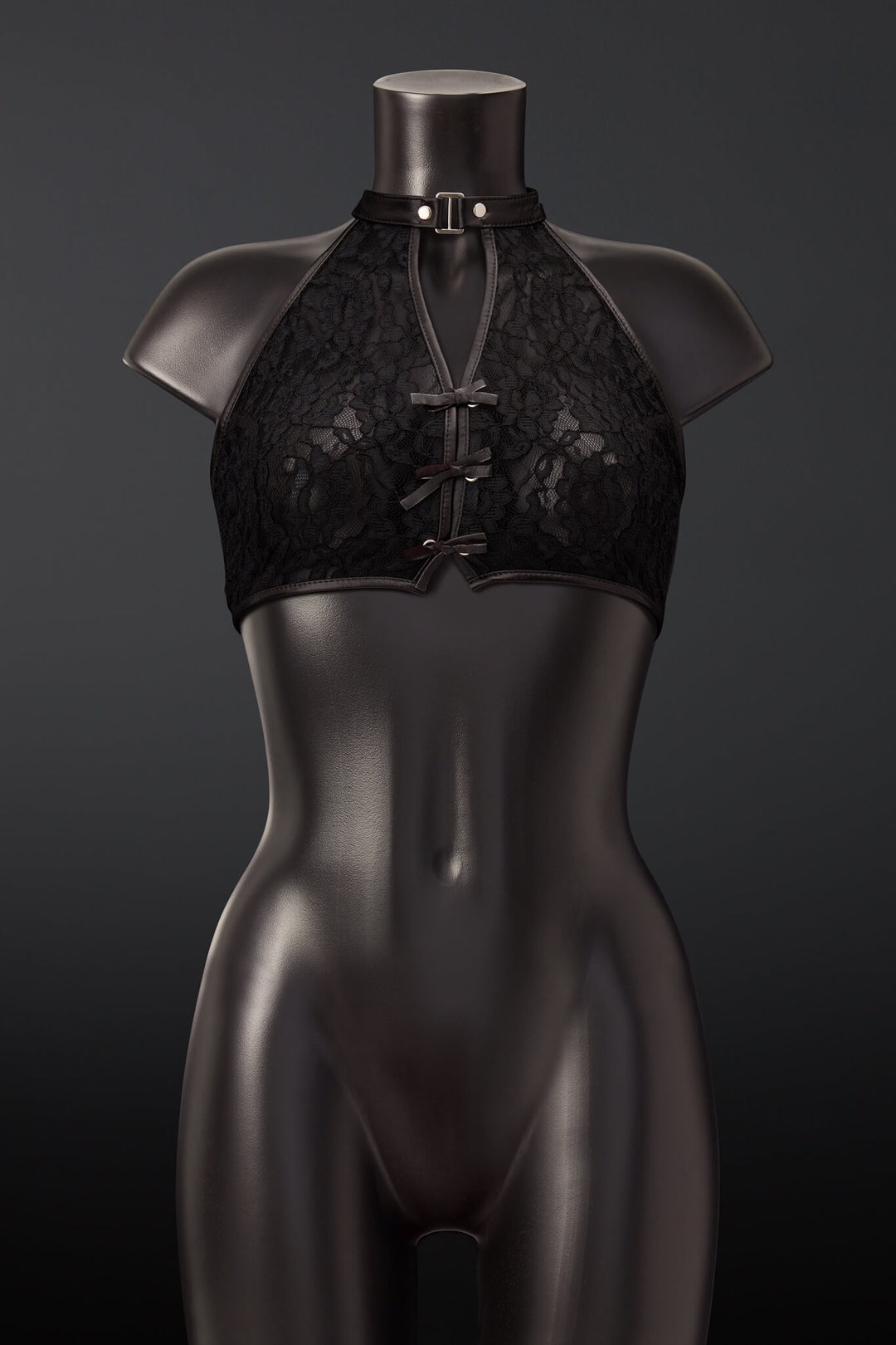 Black lace halter bralette with matching black choker collar and front lace-up closure, displayed on a glossy black mannequin torso against a dark gray background.
