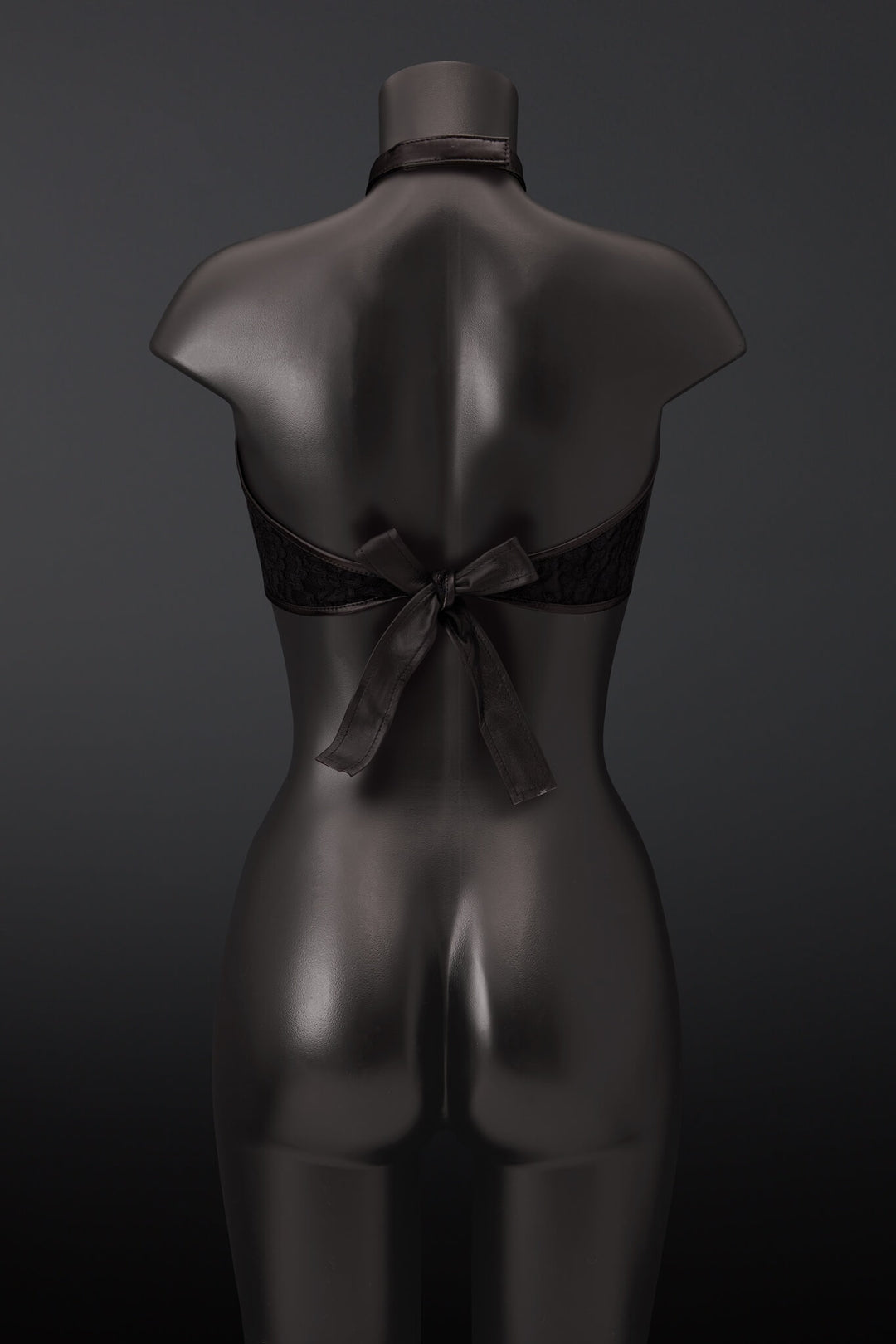 Black lace halter bra with a large leather back bow, displayed on a dark gray mannequin from the back against a dark gray background.