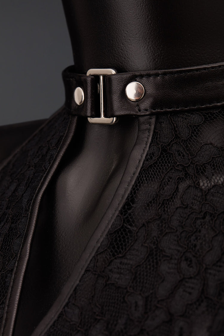 Close-up of a black eather collar with a silver metal buckle and silver rivets, worn on a black mannequin torso. The collar is paired with a black lace garment.