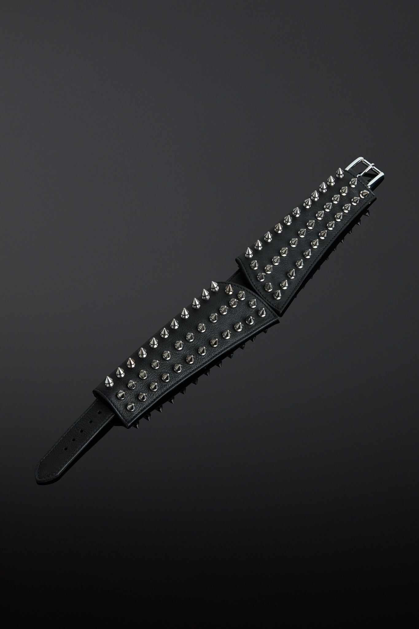 Black leather collar with silver studs on a dark gray background