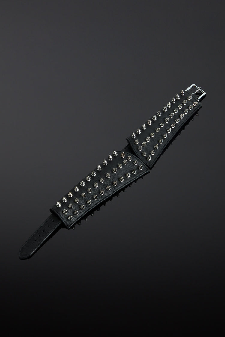 Black leather collar with silver studs on a dark gray background