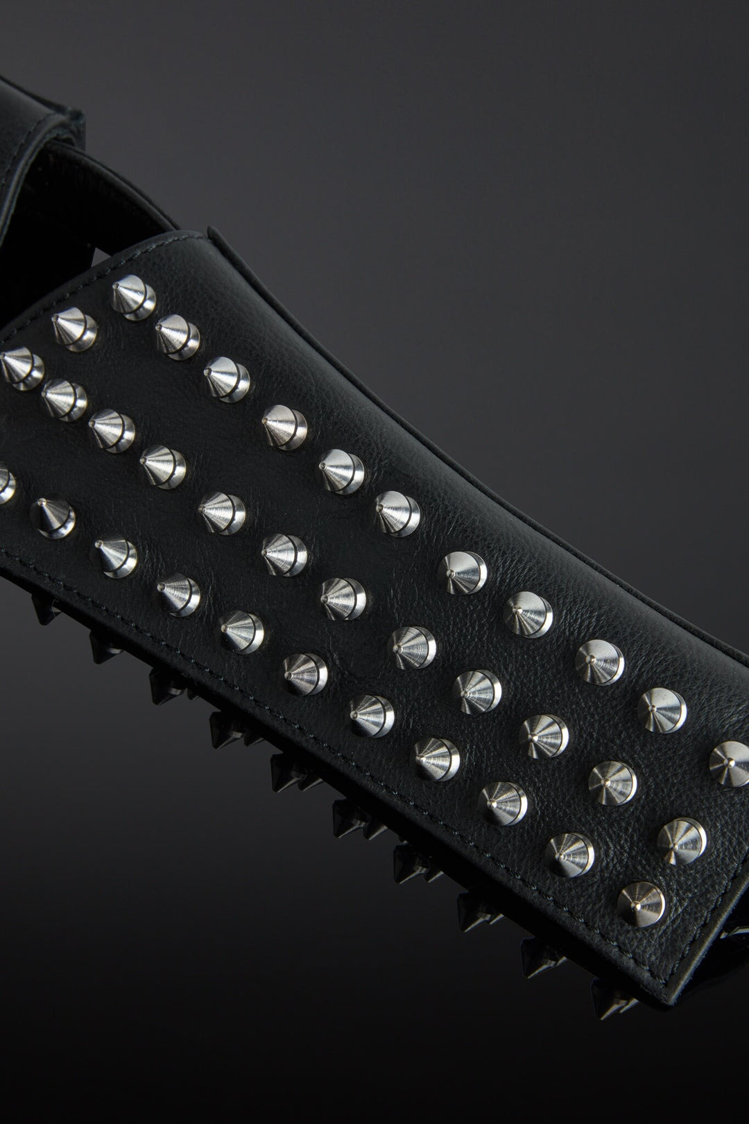 Black studded belt with silver studs on a dark background
