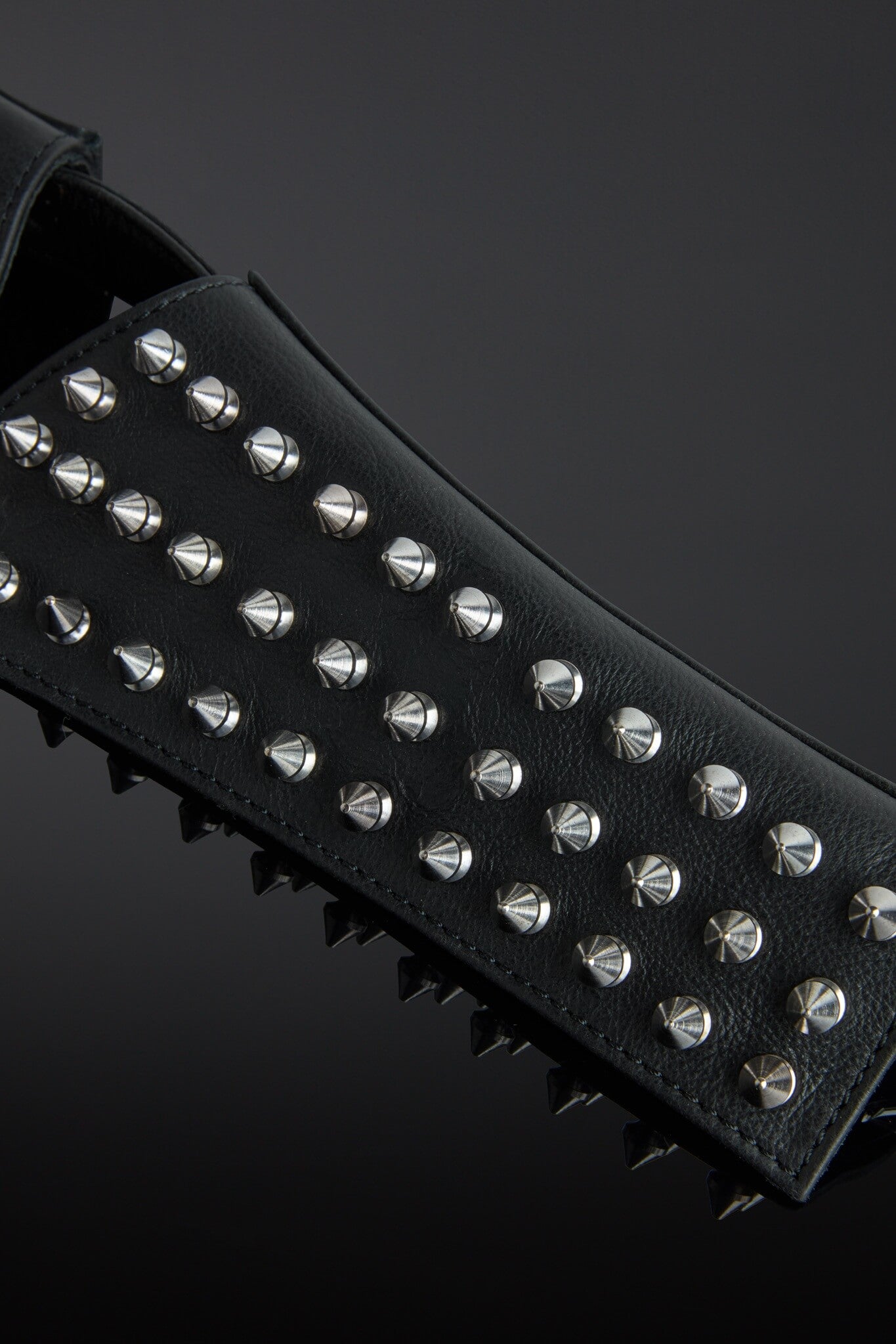 Black studded belt with silver studs on a dark background