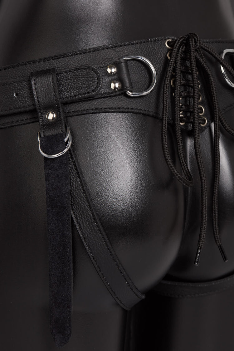 Black leather harness with metal buckles on a dark background