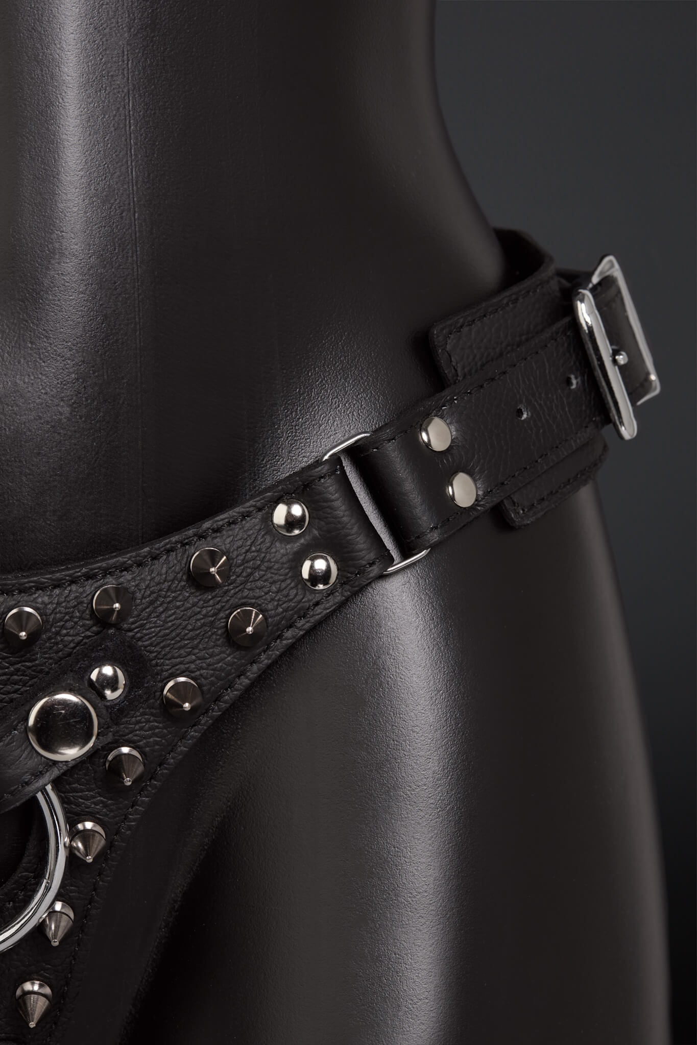 Black leather harness with studs on a dark background