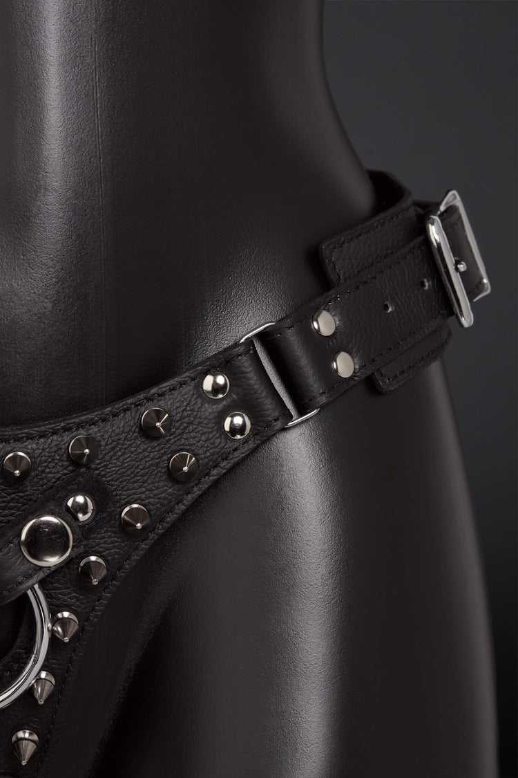 Black leather harness with studs on a dark background