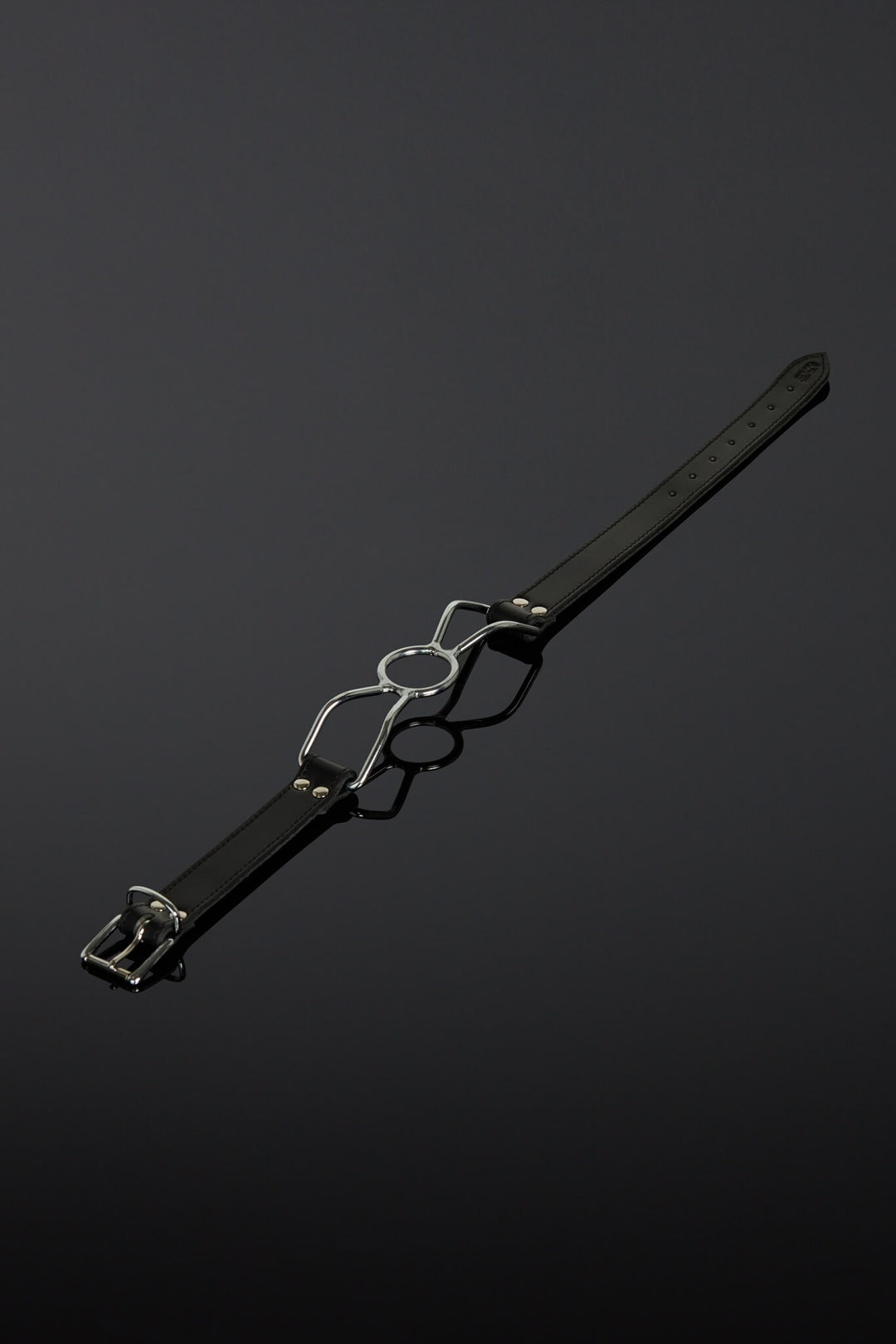 Black leather belt with silver buckle on a dark background