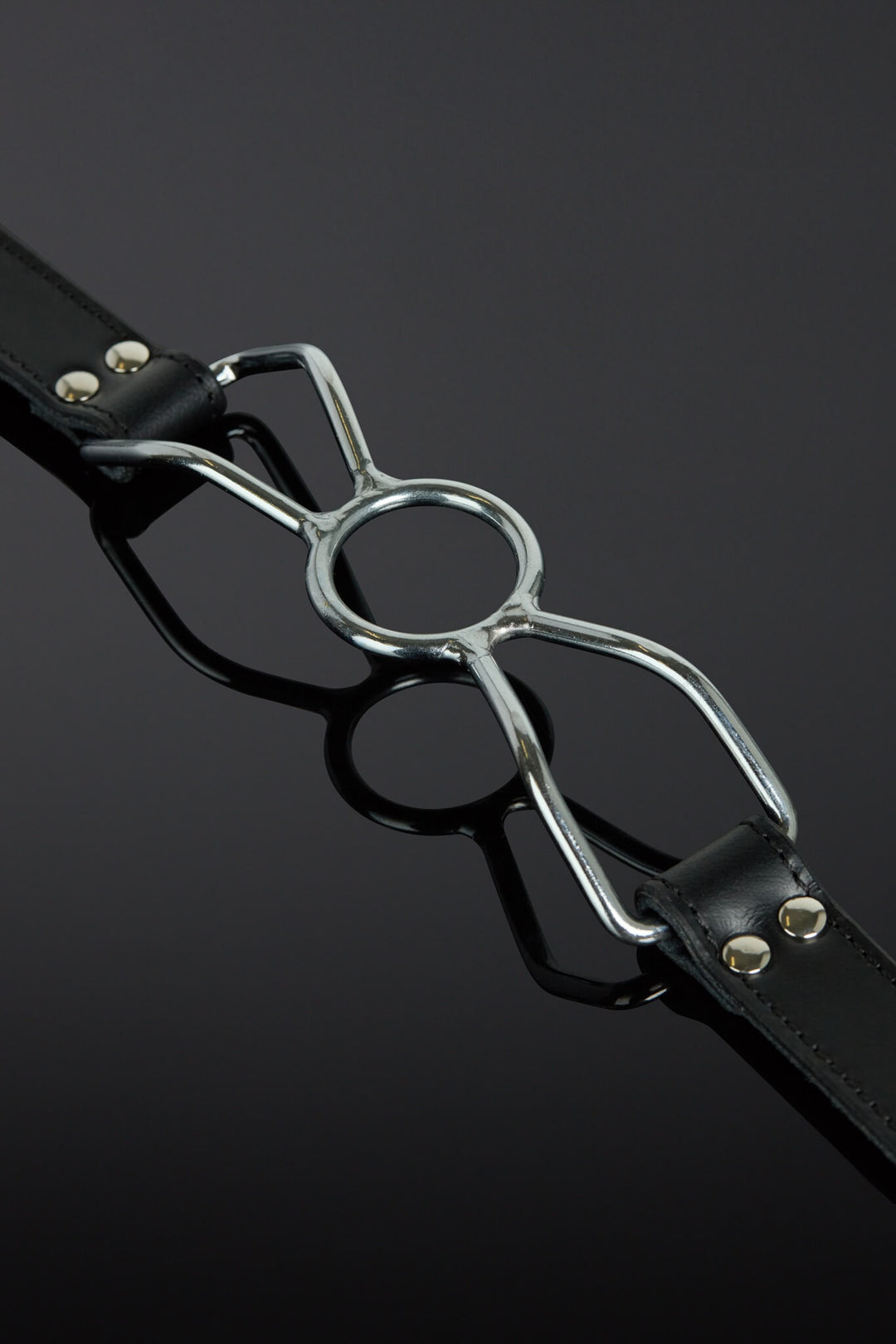 Black leather strap with a metal buckle on a dark background