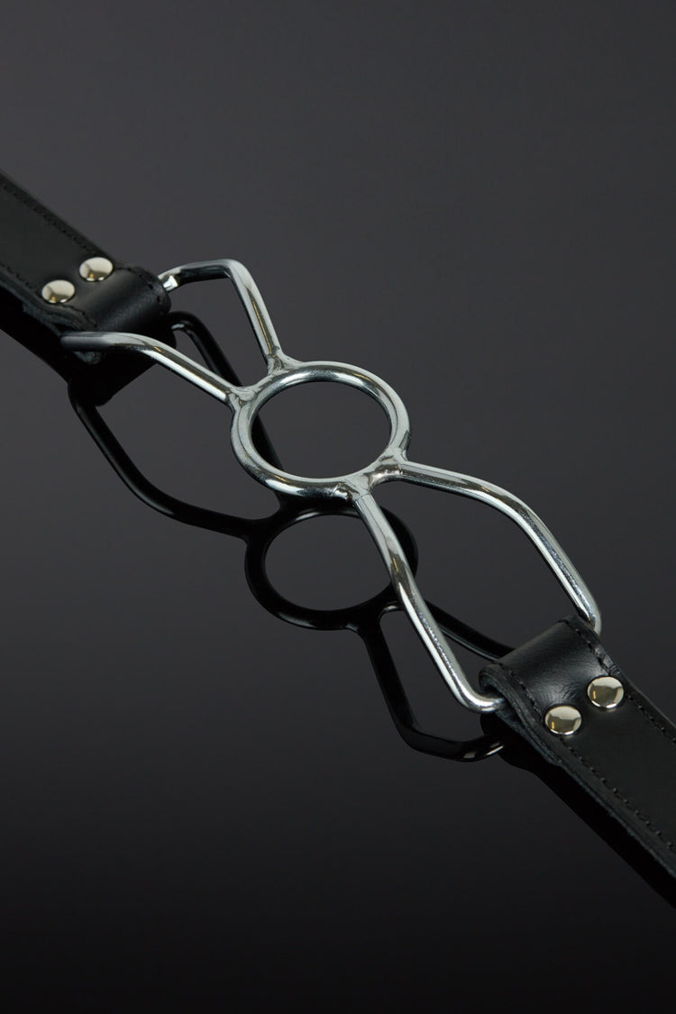 Black leather strap with a metal buckle on a dark background
