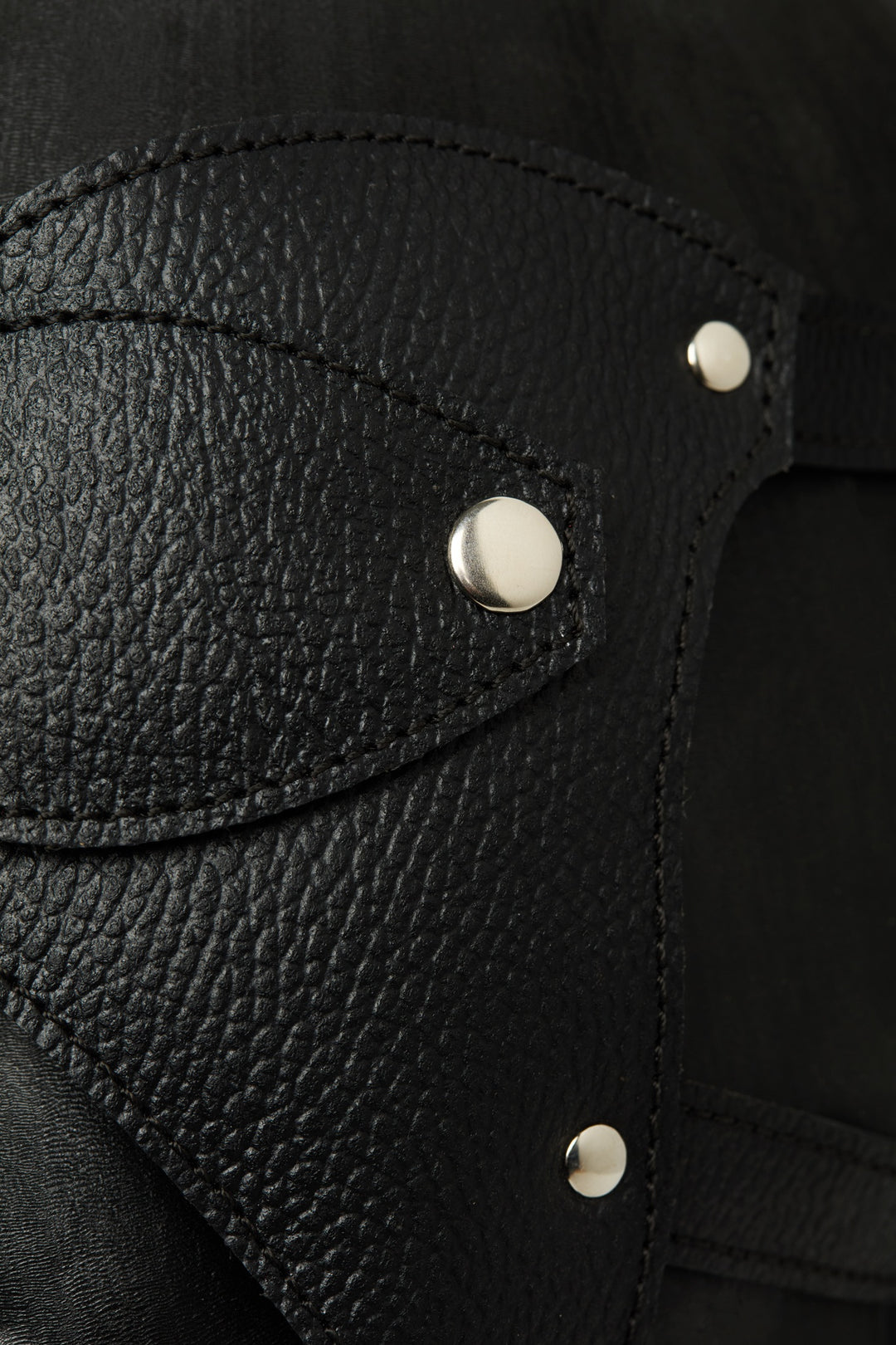 Close-up of black leather with silver buttons