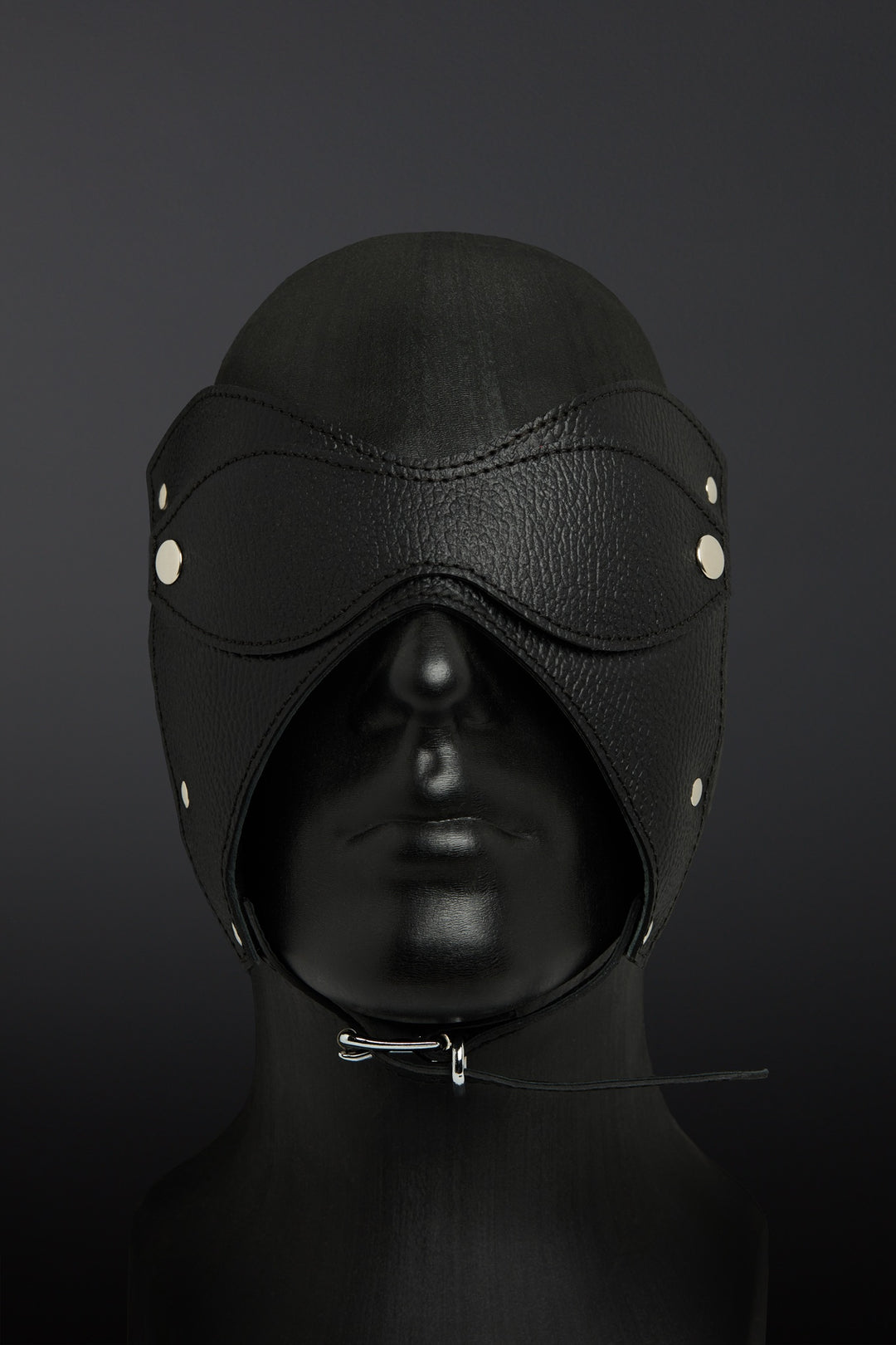 Black leather hood with eye and mouth closures on a dark background