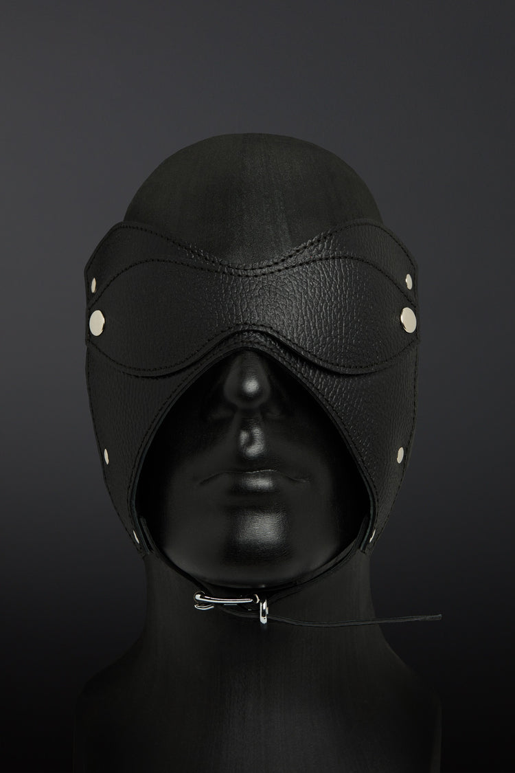 Black leather hood with eye and mouth closures on a dark background